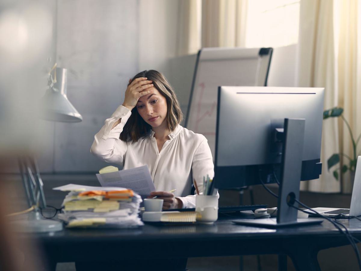 Frau gestresst am Arbeitsplatz